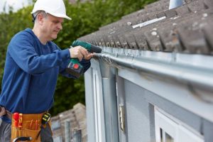 man repairing gutters