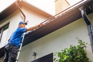 contractor inspecting a homeowner's gutters