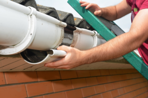 a person working on their home’s gutters