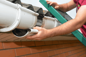 a worker on a ladder installing a gutter system