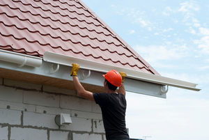 a homeowner inspecting their gutters